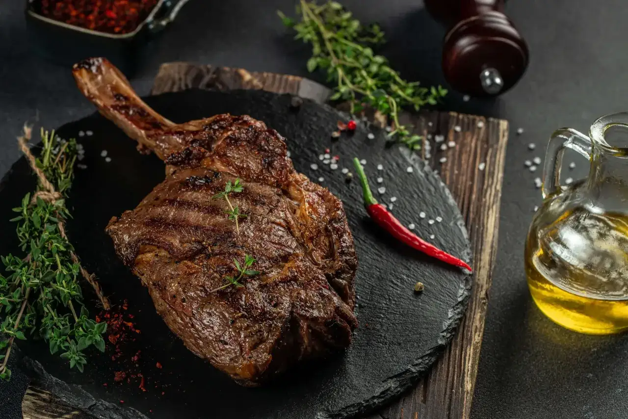 Une entrecôte barbecue juteuse, garnie de thym frais, avec du piment rouge et de l'huile d'olive.