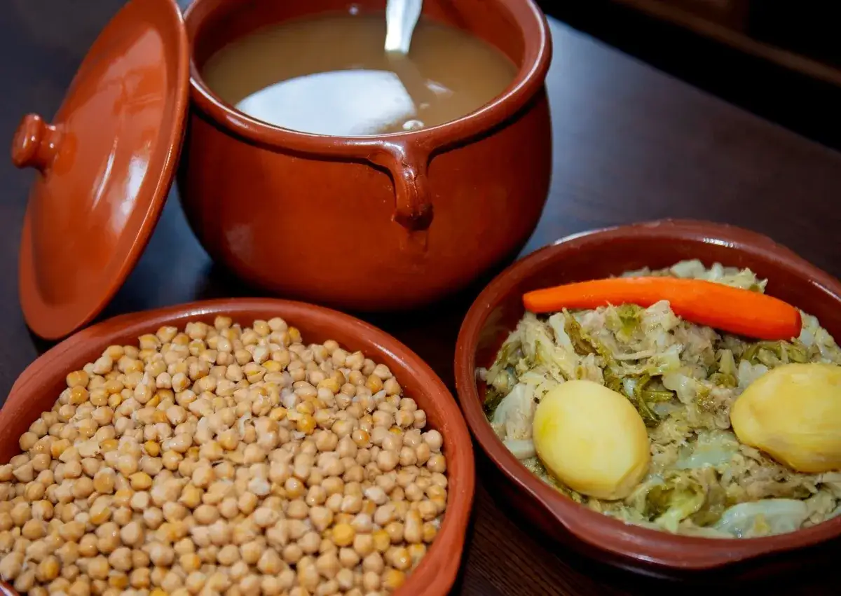 Un delicioso cocido madrile&ntilde;o en pueblos de Madrid. Garbanzos, verduras y caldo en cazuelas de barro.
