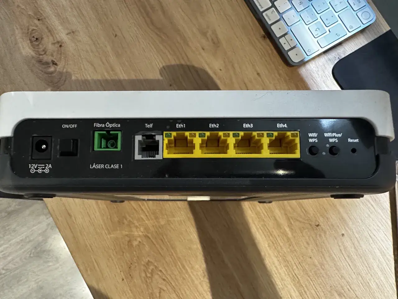Conexiones de un ont router: puerto de alimentaci&oacute;n, Fibra &Oacute;ptica, Telf, cuatro puertos Ethernet amarillos, Wifi/WPS, Wifi Plus/WPS y Reset.