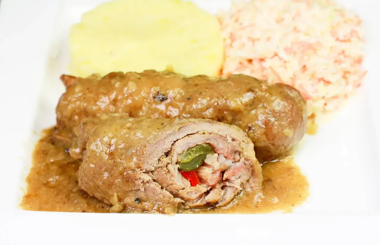 Pyszne zrazy z karkówki w sosie, podane z puree ziemniaczanym i surówką z marchewki.