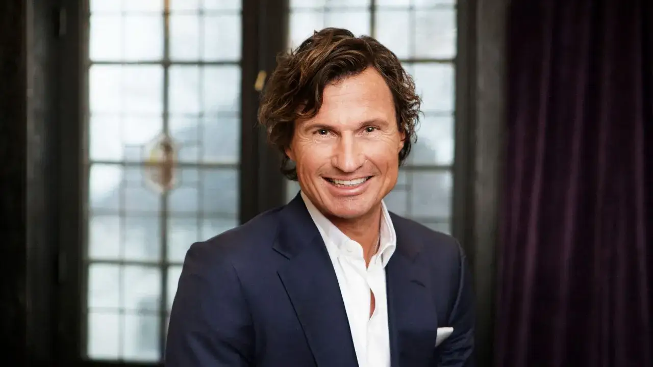 Petter Stordalen, en framgångsrik affärsman, ler mot kameran. Hans ålder syns inte på hans pigga ansikte.