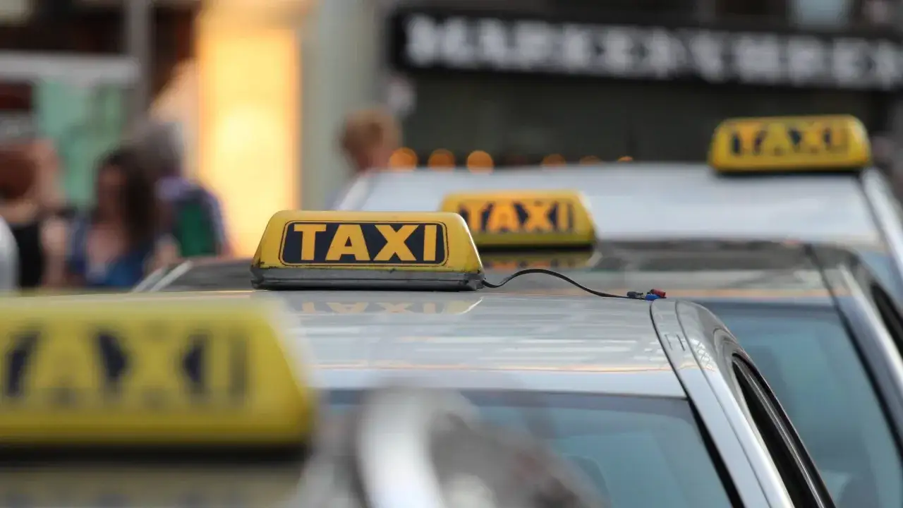Reihe von gelben TAXI-Schildern auf Autos. Ein TAXI von bis zur nächsten Stadt wartet auf Fahrgäste.