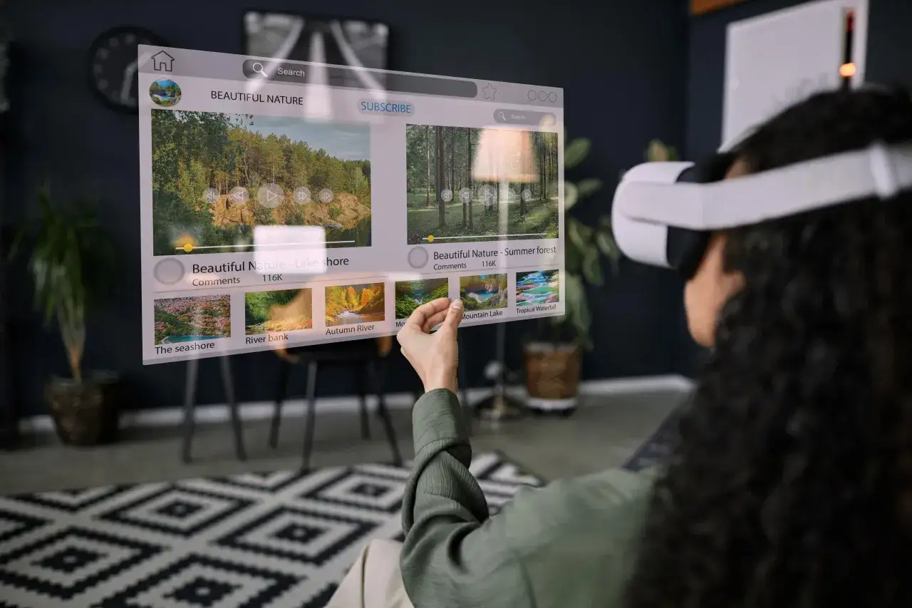 Osoba w goglach VR ogląda filmy o naturze. Widzi interfejs z miniaturkami i opisami, jak działa VR, pozwalając na interakcję z wirtualnym światem.