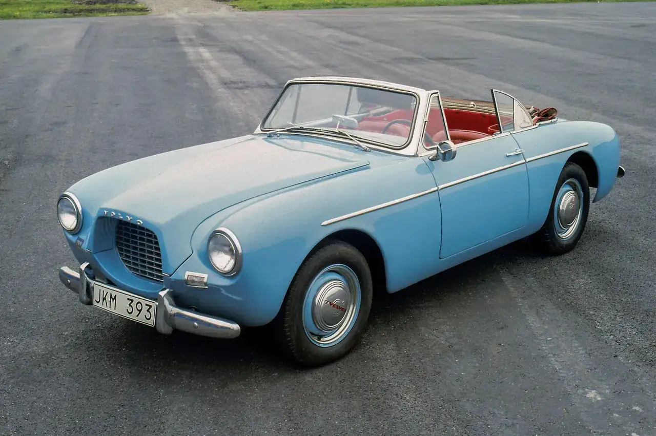 Volvo ann&eacute;e 50 d&eacute;capotable bleu ciel, int&eacute;rieur rouge vif. Un classique intemporel sur l'asphalte.