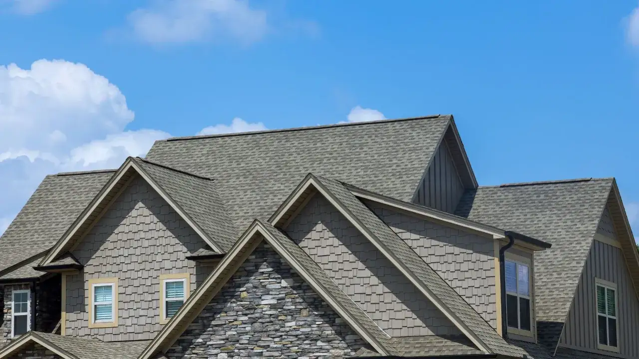 A multi-gabled roof covered in grey asphalt shingles, showcasing their durability and aesthetic appeal.