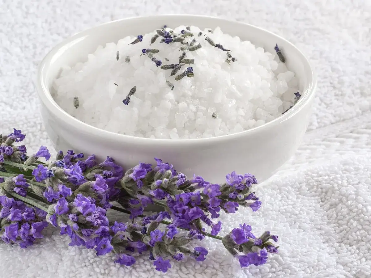 Schale mit weißem Badesalz und Lavendelblüten, ideal zum Lavendel Badesalz selber machen.