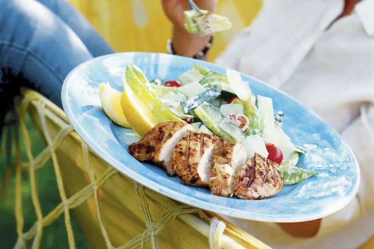 Grillad kycklingfilé med en fräsch caesarsallad, perfekt för ett somrigt ceasarsallad recept. Serveras med citronklyftor.