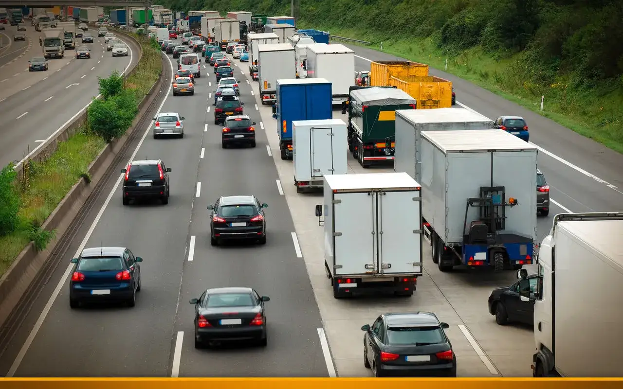 Viele LKWs und Autos auf der Autobahn. Die Frage, wie schnell darf ein LKW auf der Autobahn fahren, ist hier relevant.