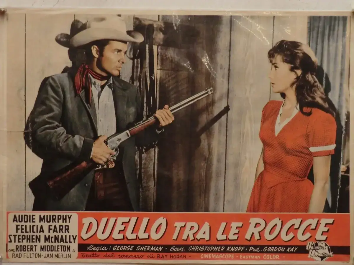 Un cowboy punta un fucile a una donna in abito rosso. Ricorda le **frasi western famose** che riecheggiano in questo duello.