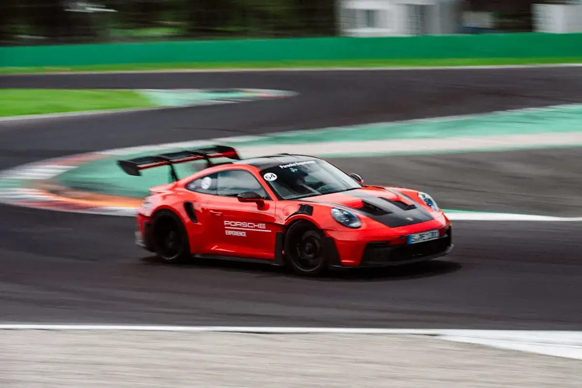 Czerwony Porsche 911 GT3 RS na torze wyścigowym. Zastanawiasz się nad porsche 911 gt3 rs cena? Ten model to marzenie każdego fana motoryzacji.