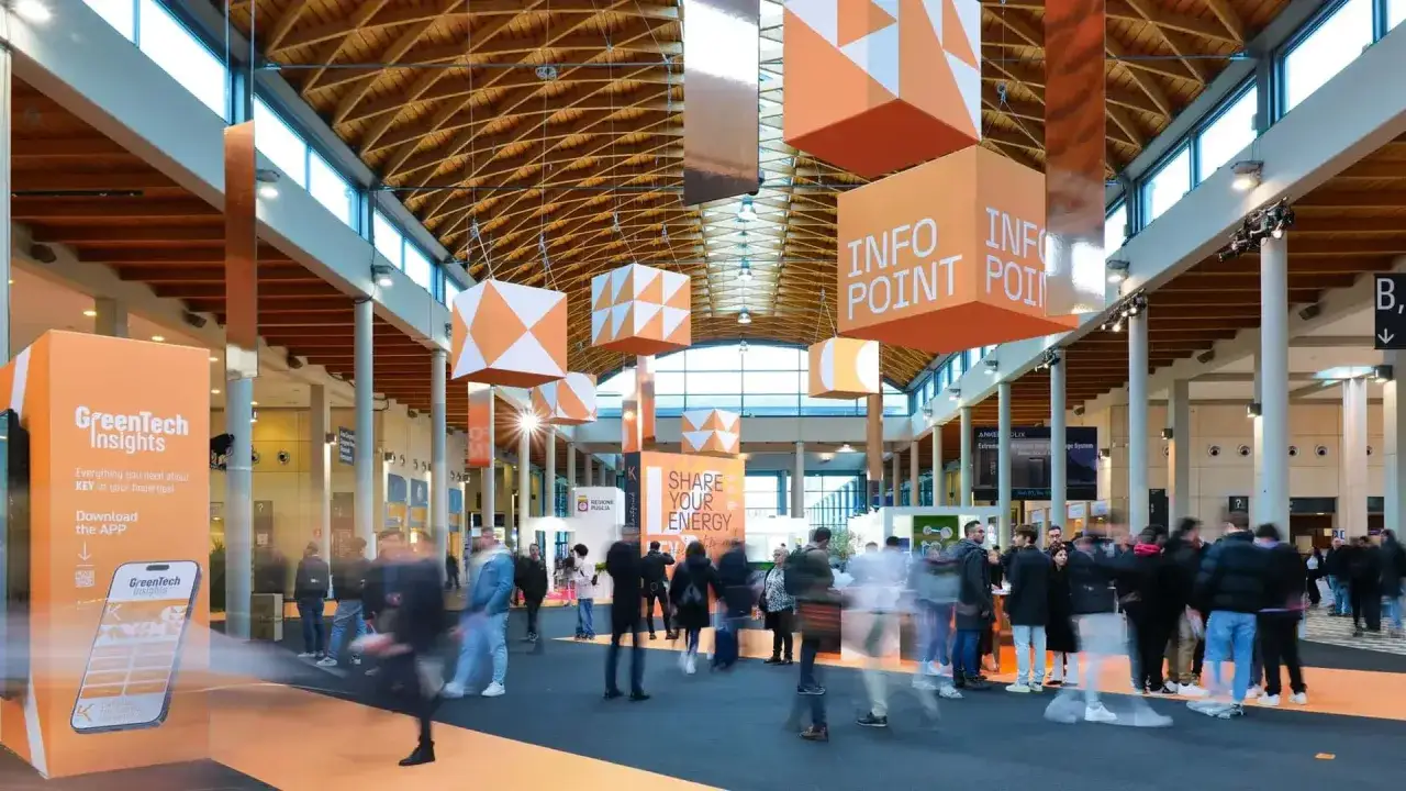 Fiera Rimini: un'affollata fiera Key Energy con stand colorati, cubi sospesi 