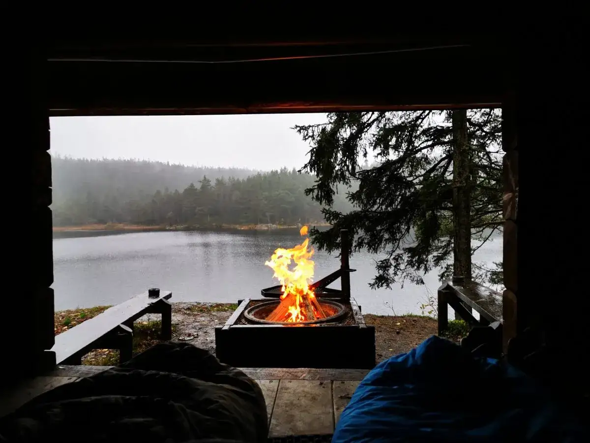 Varm eld sprakar vid en sj&ouml;, perfekt f&ouml;r att sova i vindskydd.