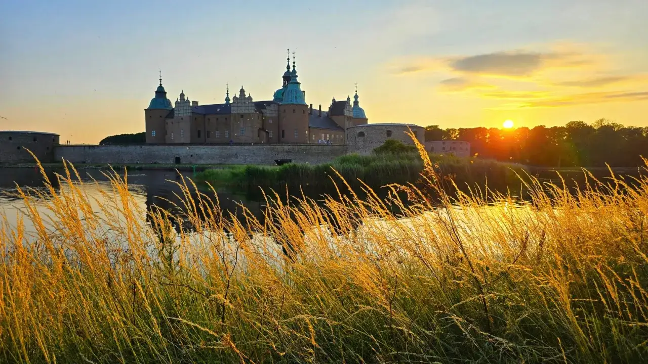 Kalmar slott badar i solnedgångens gyllene ljus, ett perfekt utflyktsmål Kalmar för en magisk kväll.