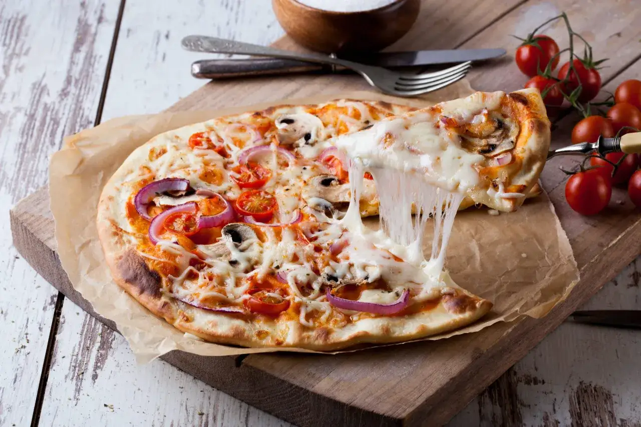 Pizza con queso derretido, tomates y cebolla. ¡Qué delicia!