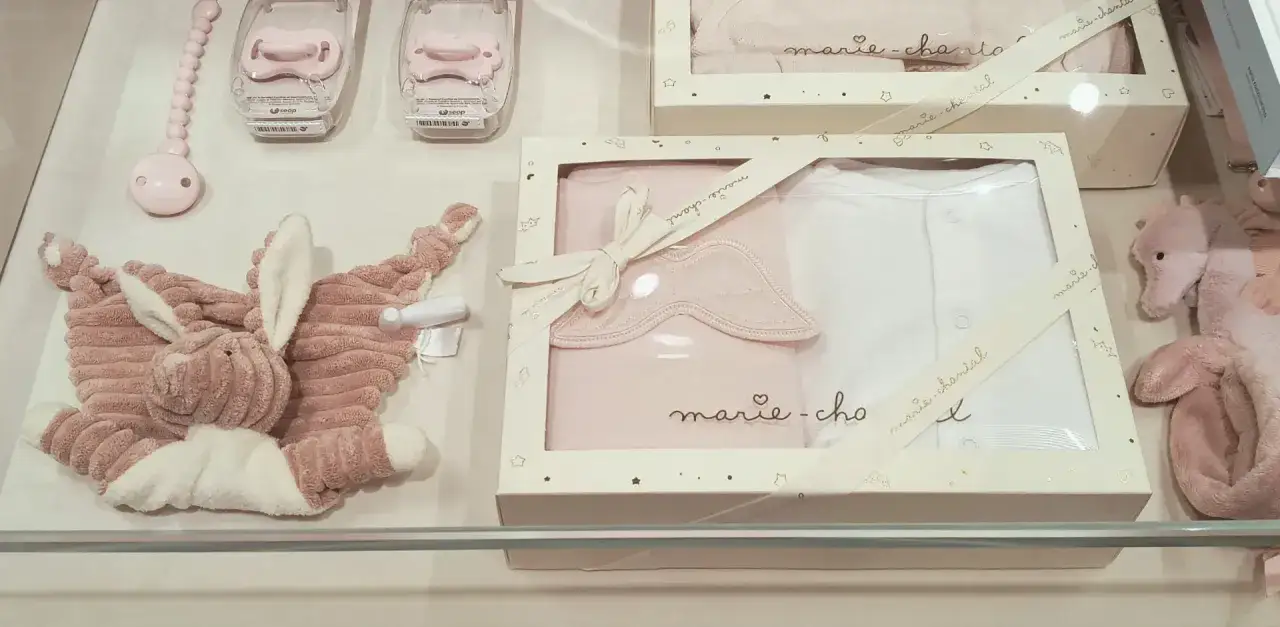 R&oacute;żowe akcesoria dla niemowląt: przytulanka, smoczki i zestaw ubranek. Idealne na baby shower, zastanawiasz się, ile dać na baby shower?