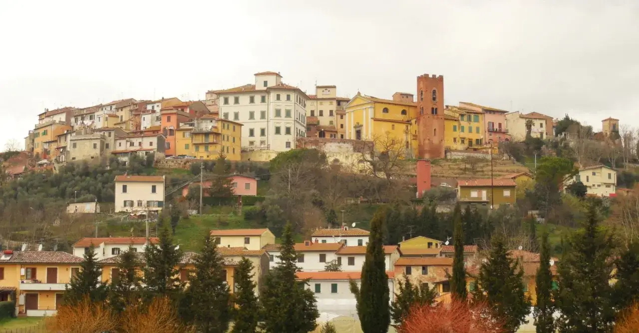 Borgo collinare di Santa Maria a Monte, con case colorate e una torre medievale che domina il paesaggio.