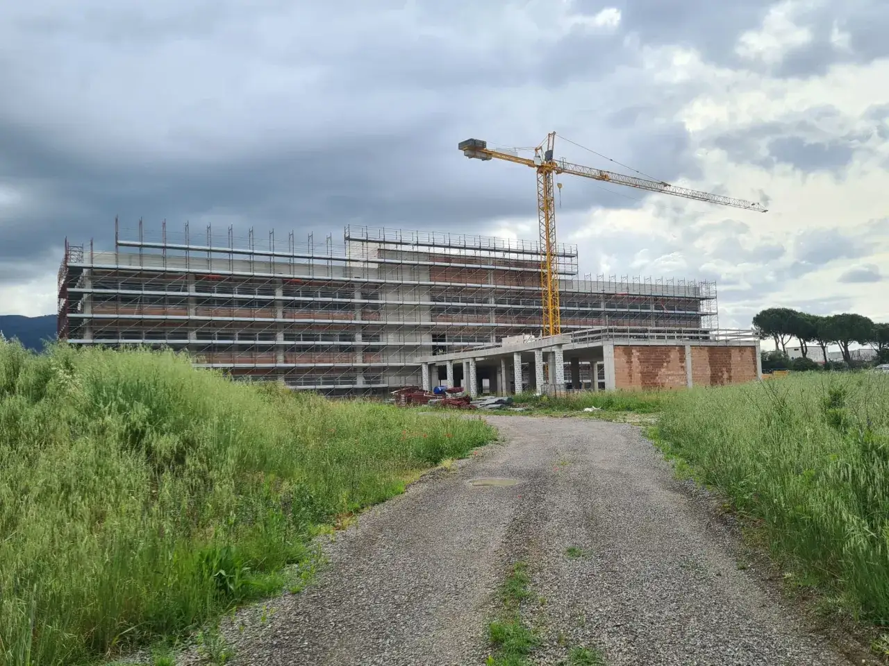 Cantiere di una grande costruzione casa da zero, con gru gialla e impalcature.