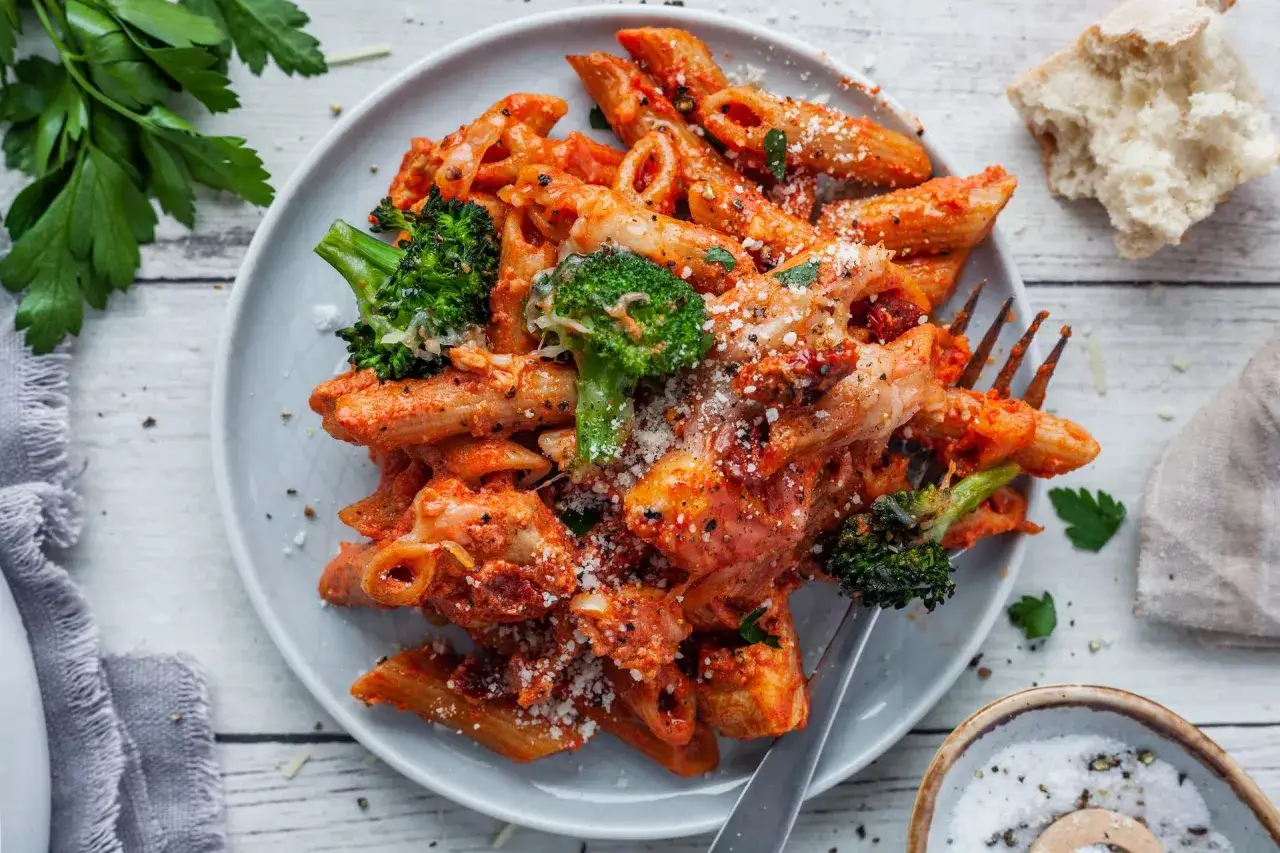 Penne z kurczakiem i brokułami w sosie pomidorowym, posypane parmezanem. Idealny przepis na szybki obiad.