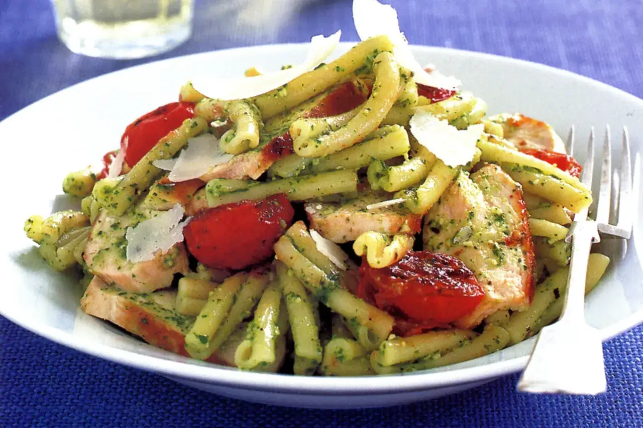 Makaron z kurczakiem, pomidorkami i parmezanem, polany aromatycznym **makaronem z pesto ze słoika**. Pyszne danie gotowe w mig!