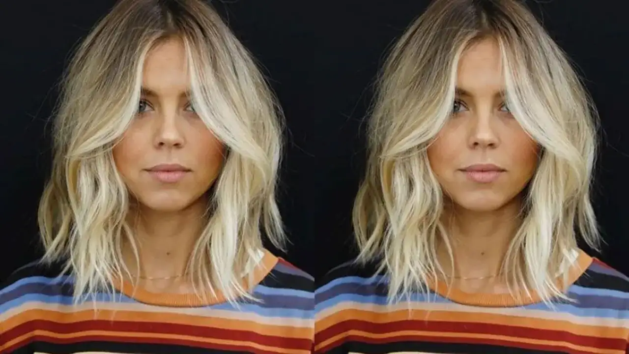 Kobieta z blond włosami w stylu long bob, z pasemkami opadającymi na twarz, w kolorowym swetrze.