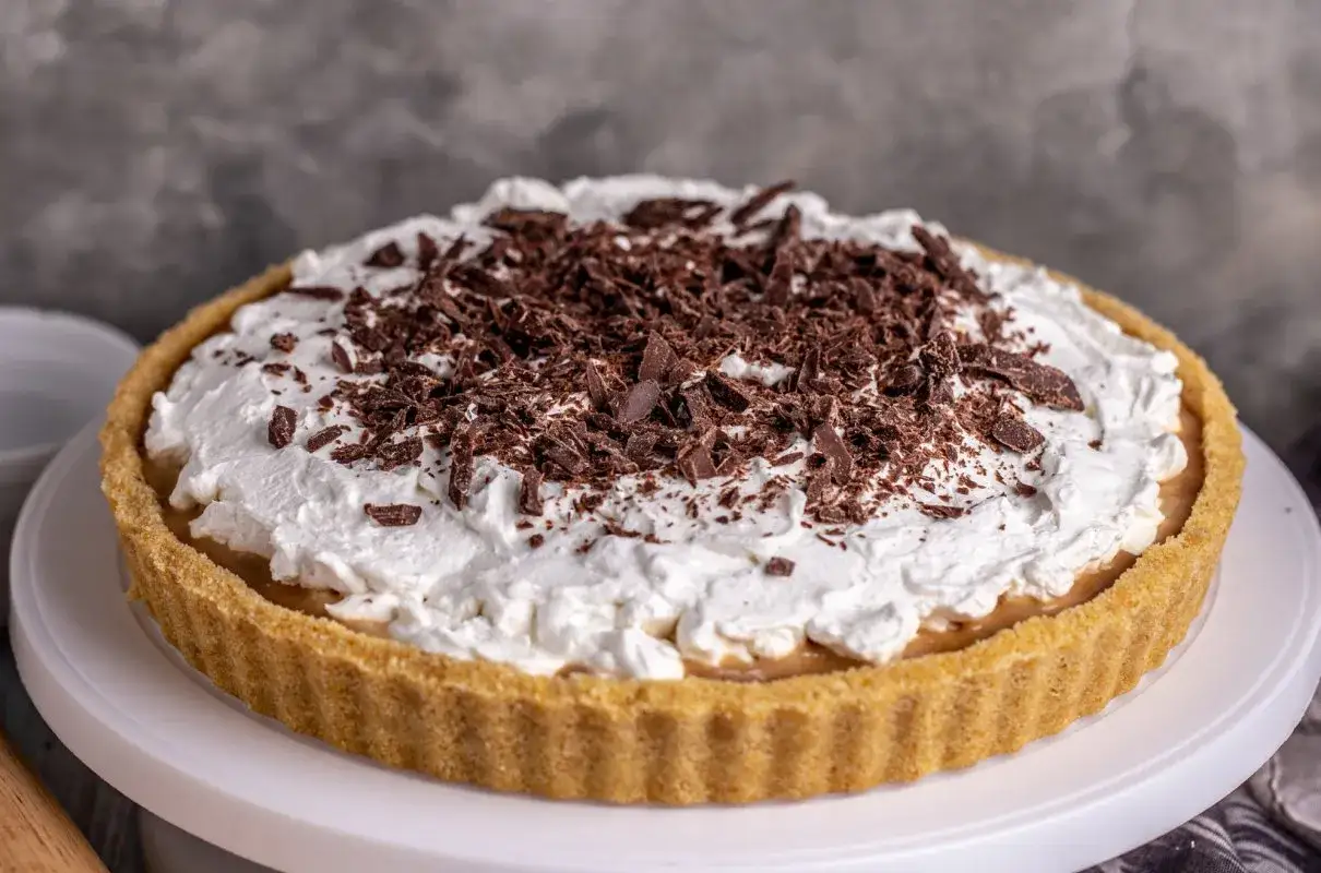 Pyszna tarta Kinder Bueno z kremem i wiórkami czekolady, idealna na deser.