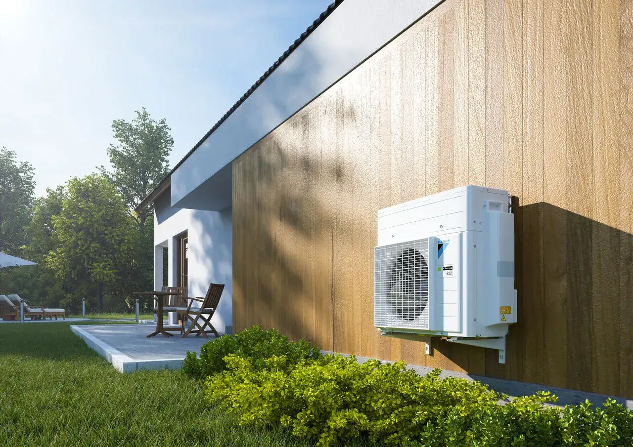 Nowoczesny piec do domu 200m2 - jednostka zewnętrzna pompy ciepła Daikin zamontowana na ścianie domu.