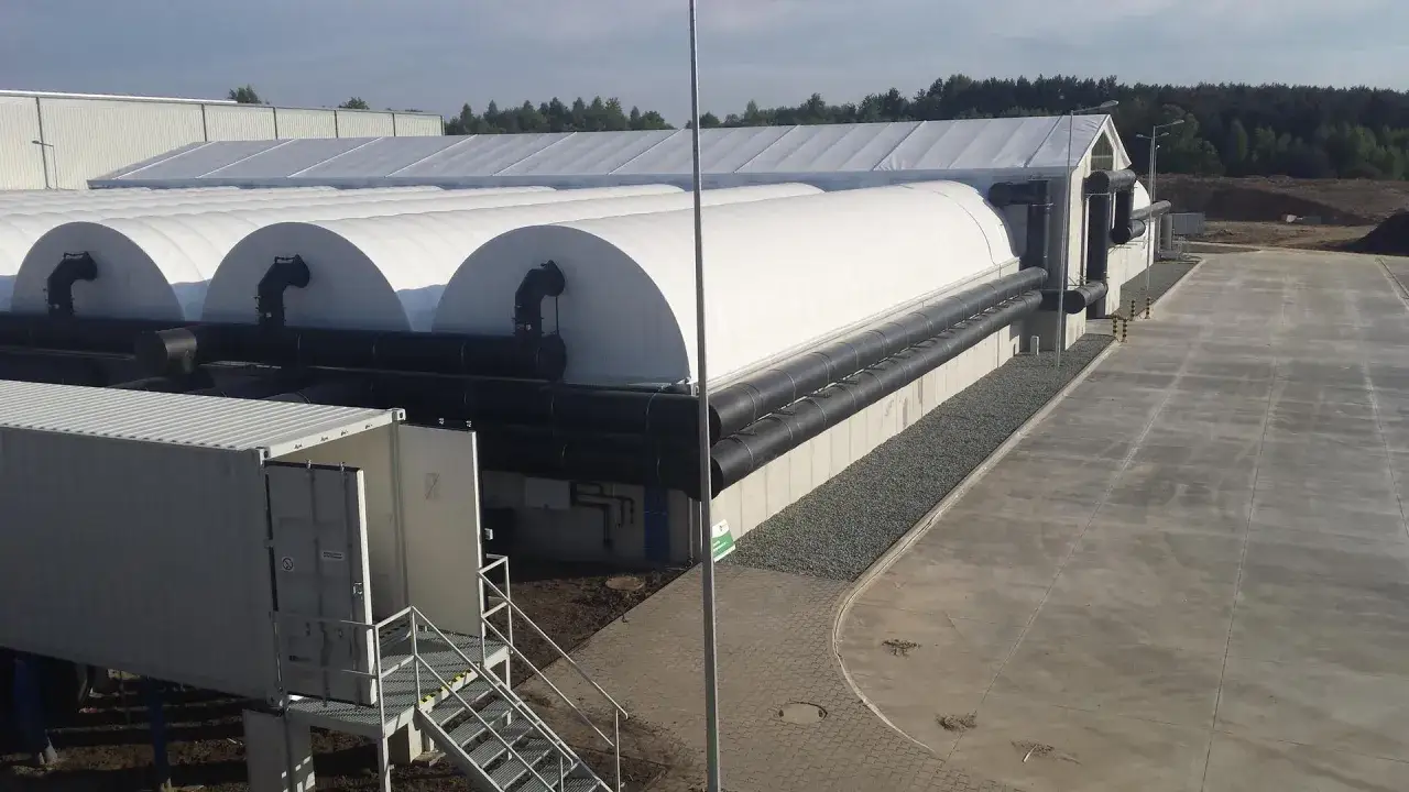 Nowe obiekty do przetwarzania odpad&oacute;w na paliwo. Białe, łukowate konstrukcje z czarnymi rurami.