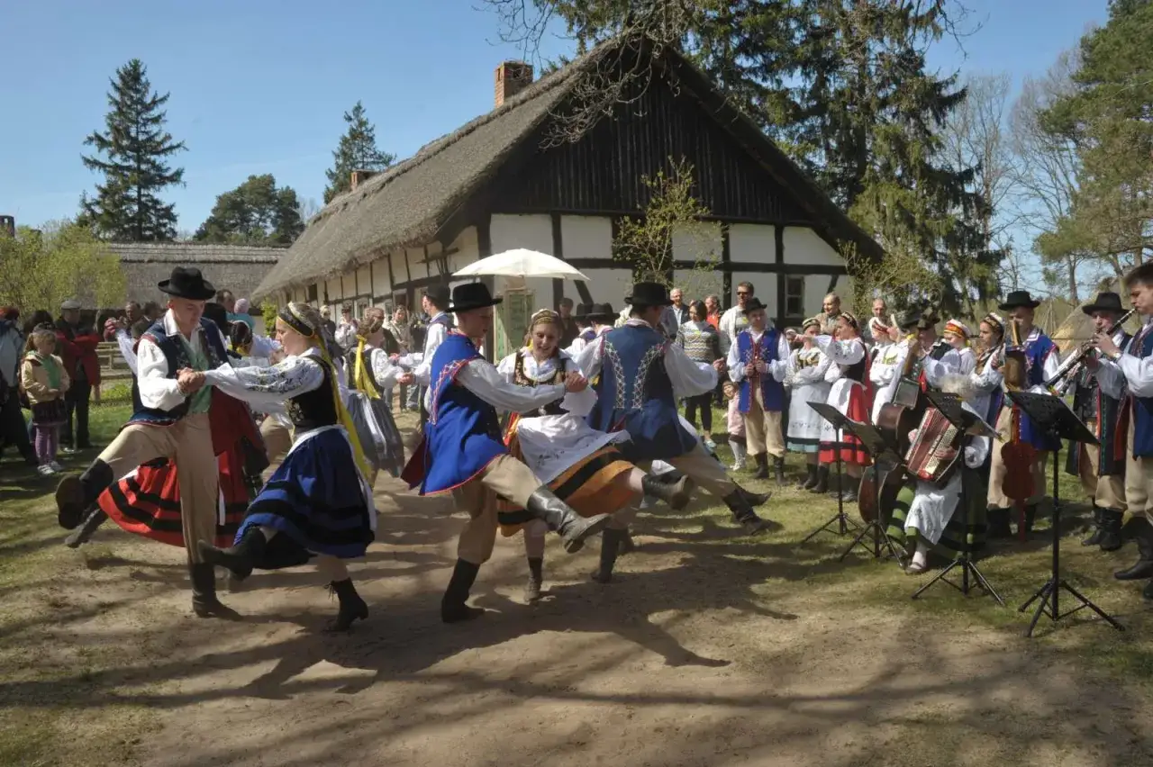 Ludowy zespół tańczy w tradycyjnych strojach, a zespół muzyczny gra. Wspaniałe kluki atrakcje dla każdego!