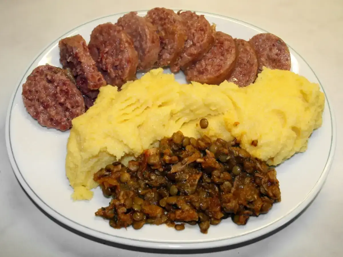 Piatto con cotechino affettato, polenta gialla e lenticchie. Si nota la differenza tra cotechino e musetto per la grana più grossa del primo.