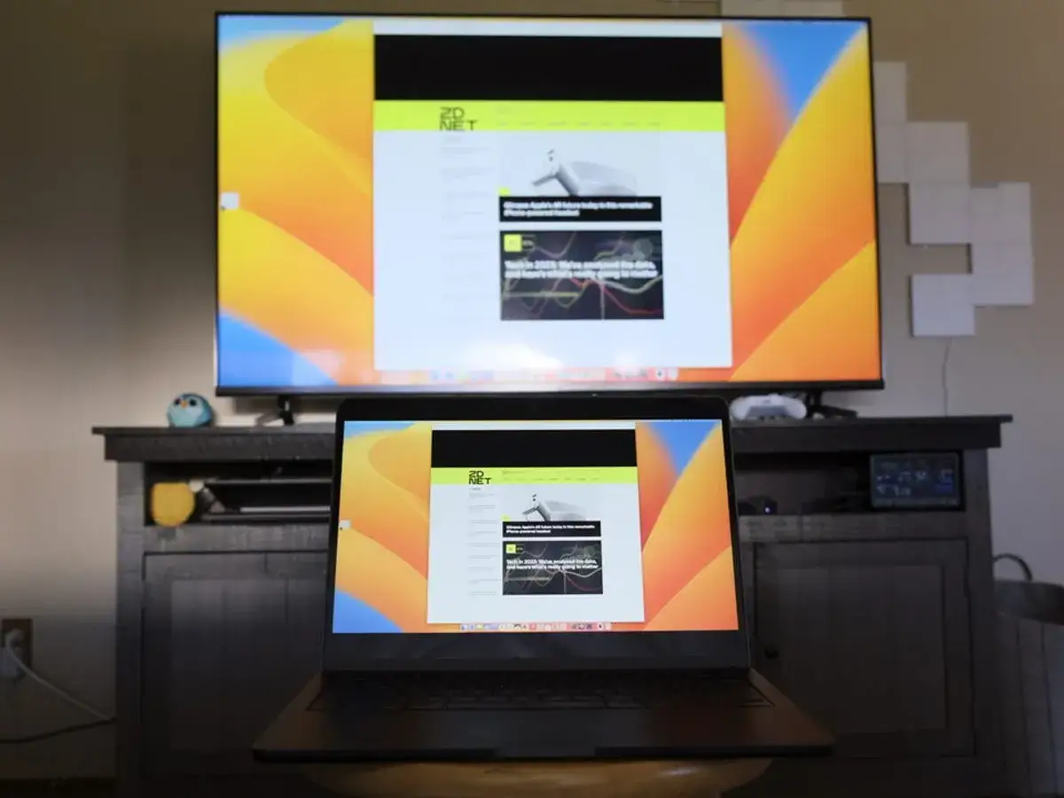 Configuration pour projeter &eacute;cran PC sur TV HDMi. Un ordinateur portable affiche un site web, dupliqu&eacute; sur un grand &eacute;cran TV.