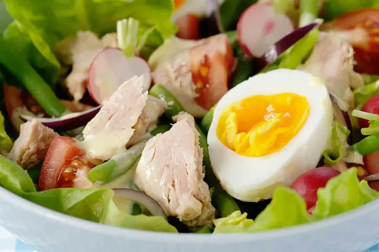 En härlig tonfisk sallad med ägg, tomat, rädisor och gröna bönor, allt täckt av en krämig dressing.