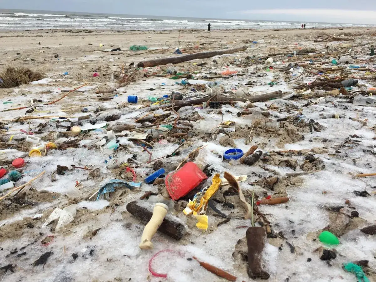 Zanieczyszczona plaża z plastikiem i śniegiem. Gdzieś tam, wśród śmieci, można by znaleźć bursztyny nad morzem, gdyby nie ten bałagan.