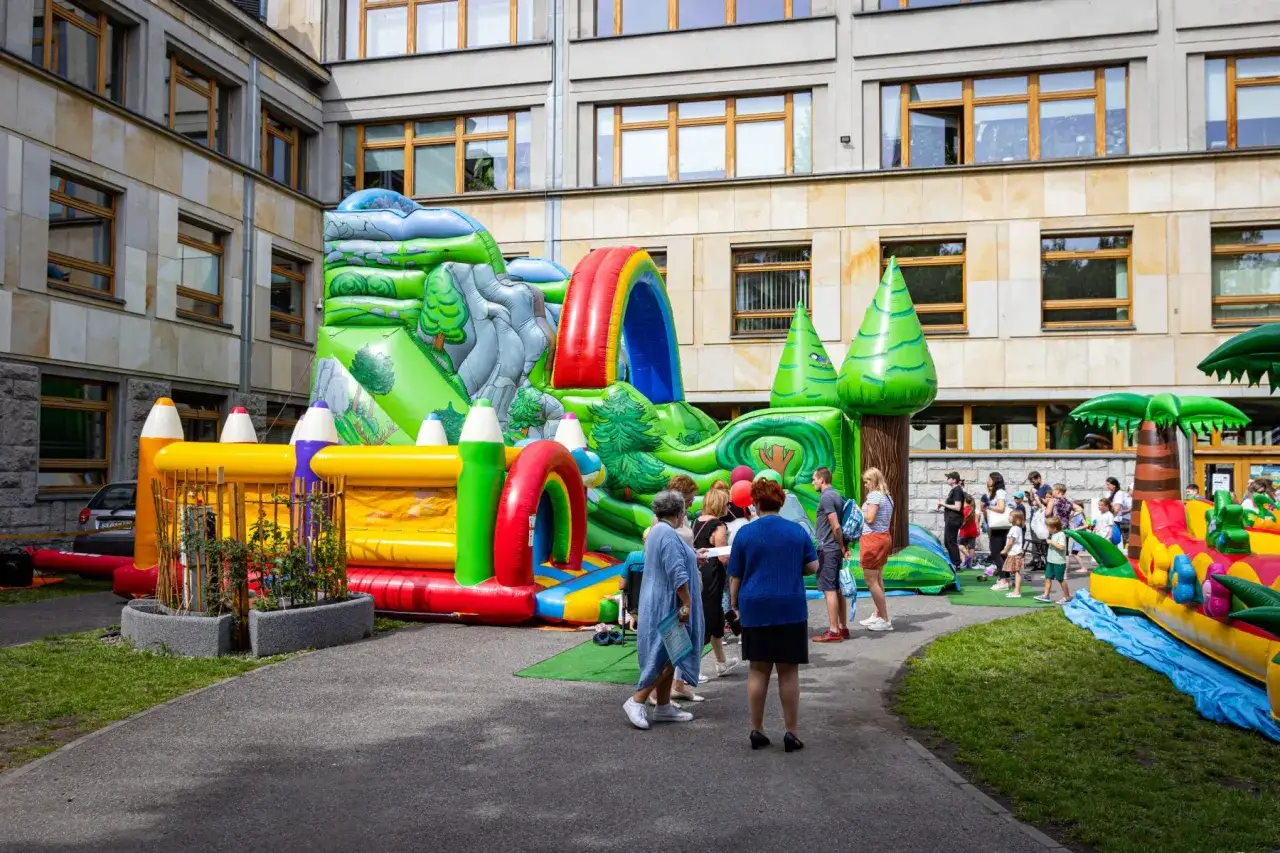 Kolorowe dmuchańce i plac zabaw to świetne katowice atrakcje dla dzieci. Rodziny cieszą się słońcem i zabawą.