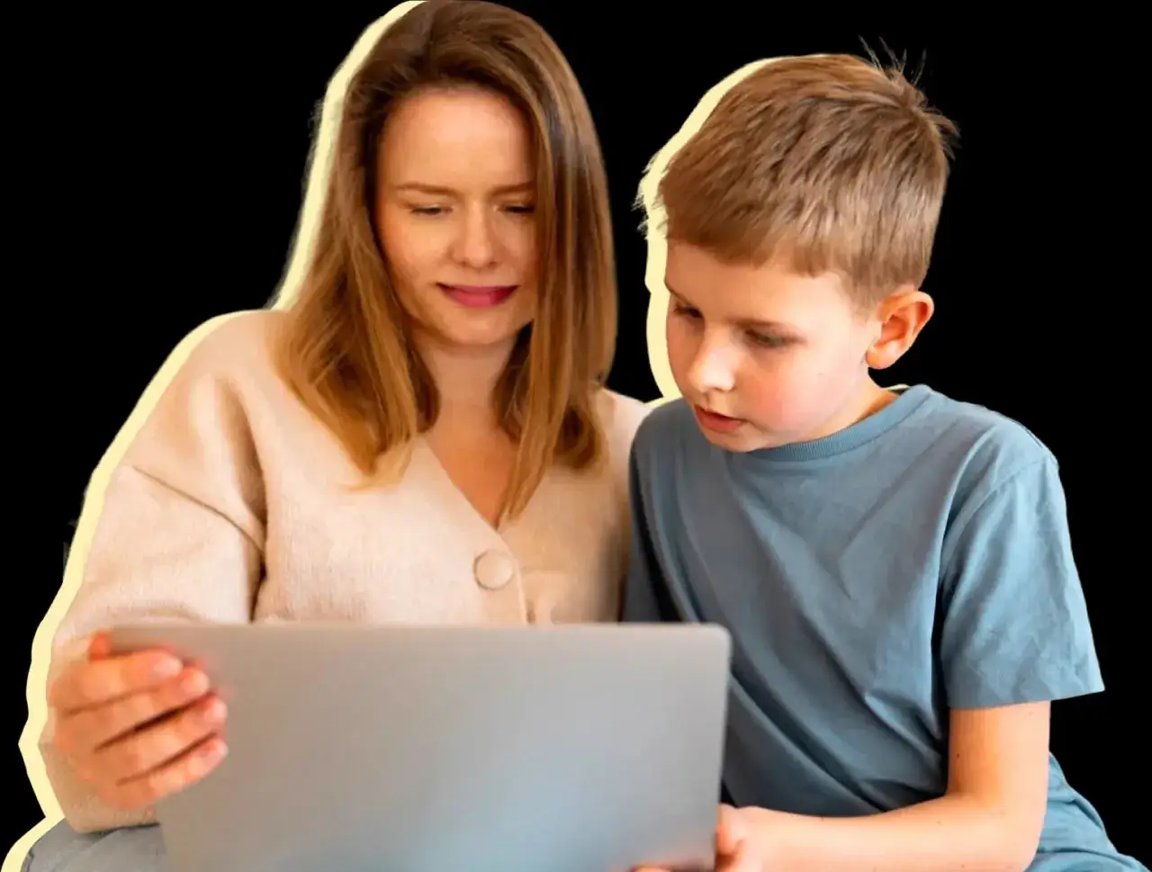 Mutter und Sohn schauen gemeinsam auf einen Laptop. Sie lernen, um eine Lernschwäche zu überwinden.