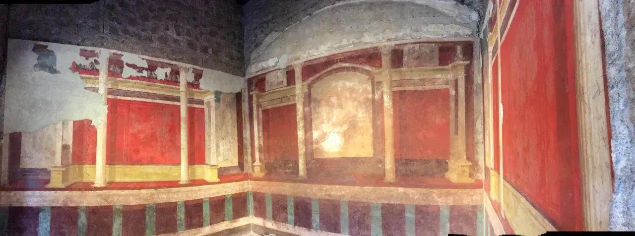 Fresques murales color&eacute;es dans une pi&egrave;ce, &eacute;voquant l'int&eacute;rieur d'une maison d'Auguste &agrave; Rome. Les motifs architecturaux et les couleurs vives rappellent l'art romain antique.