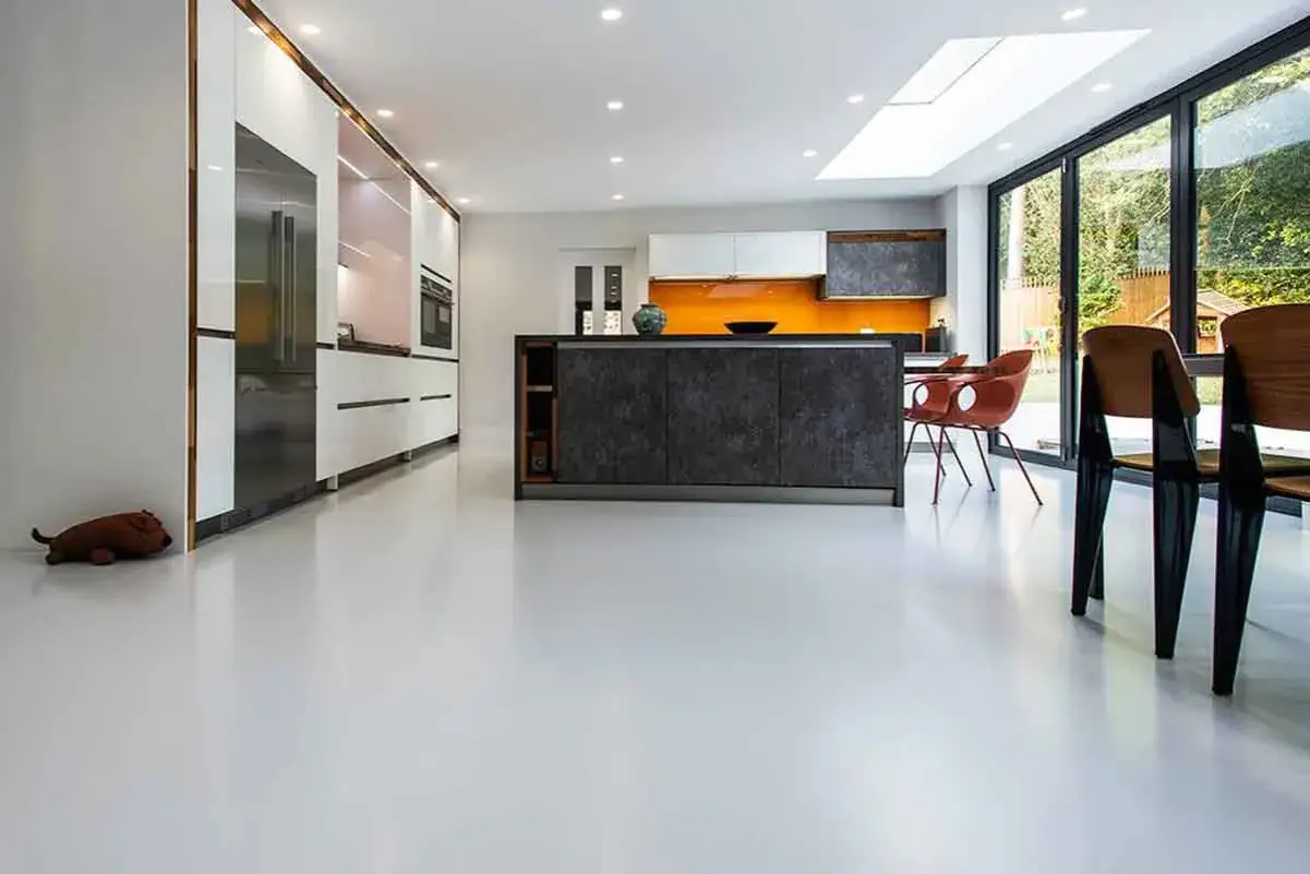 Cucina moderna con isola centrale e pavimenti in resina chiara. Valuta i prezzi pavimenti in resina per un look contemporaneo.