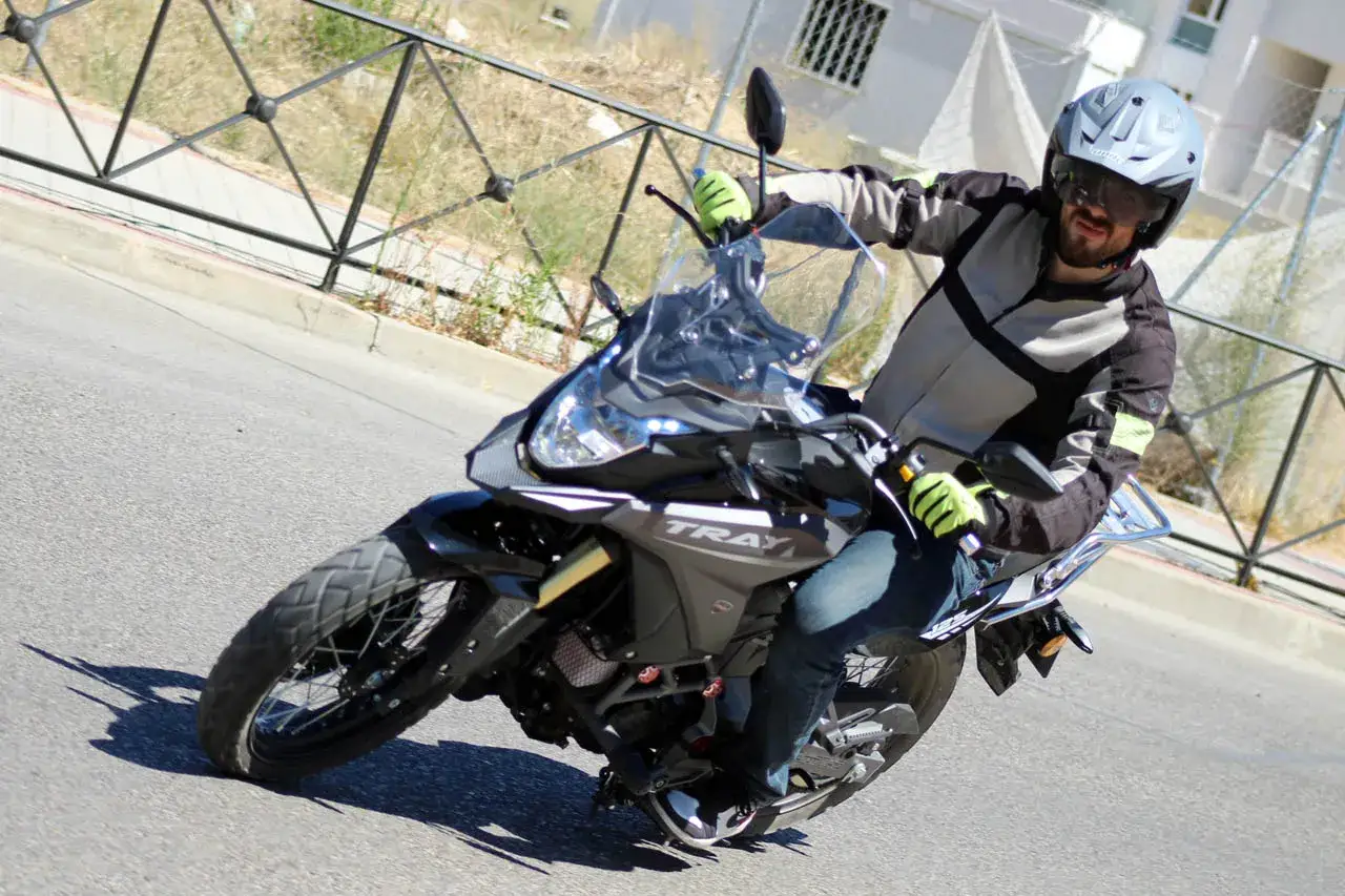 Hombre con casco y chaqueta de moto, conduciendo una moto de 125cc por la carretera. &iexcl;S&iacute;, con una moto de 125 se puede ir por autopista!