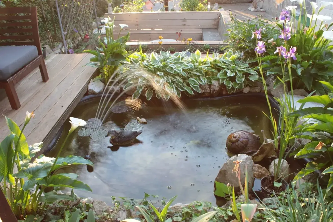 Ein kleiner Gartenteich mit Wasserspiel, Seerosen und Zierenten. Tolle Gartenteich Ideen f&uuml;r eine Oase der Ruhe.