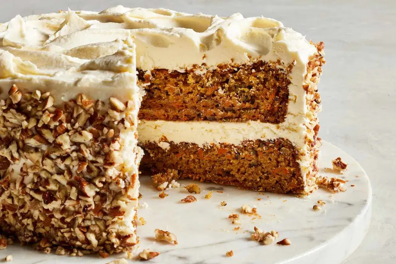 Tarta de zanahoria y queso con cobertura cremosa y nueces picadas. ¡Un postre irresistible!