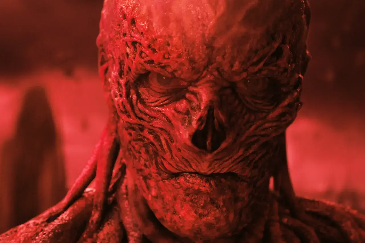 Przerażająca twarz Vecny z Stranger Things 4, z czerwonymi, pofałdowanymi rysami i pustymi oczami, budzi grozę.