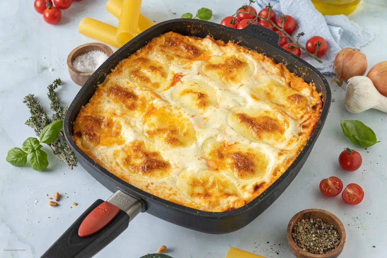 &Uuml;berbackene Cannelloni in einer Pfanne, goldbraun gebacken, mit geschmolzenem K&auml;se und Tomatensauce. Ein k&ouml;stliches Cannelloni Rezept.