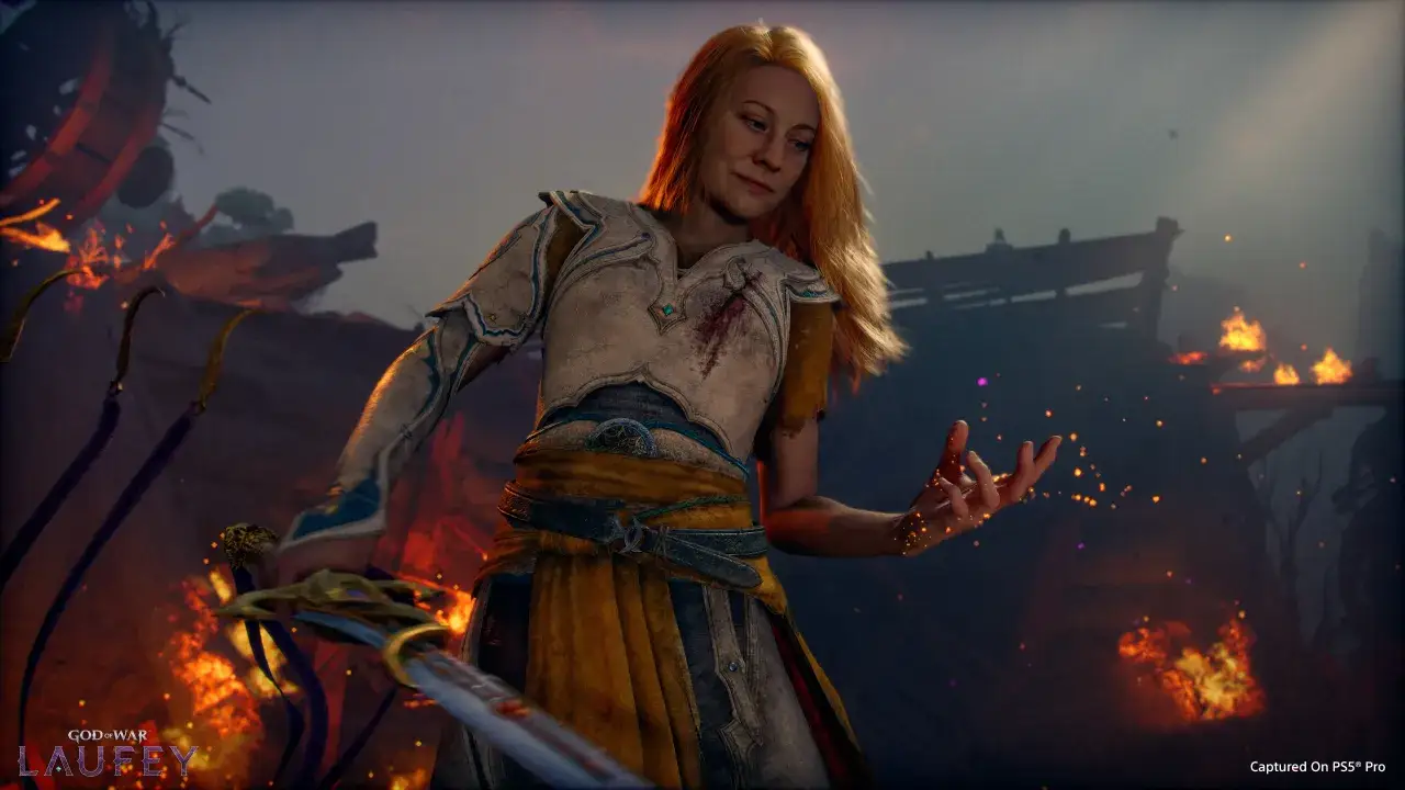 Laufey, post-bitwa, z mieczem w dłoni i iskrzącymi się palcami, w tle płonące ruiny. Dzieło Santa Monica Studio.