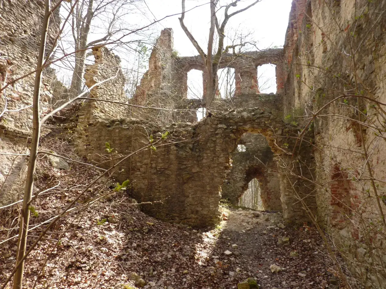 Verfallene Burgruine mit steinernen Mauern und B&ouml;gen, die wie ein hoch aufragendes Hochhaus in der Natur steht.