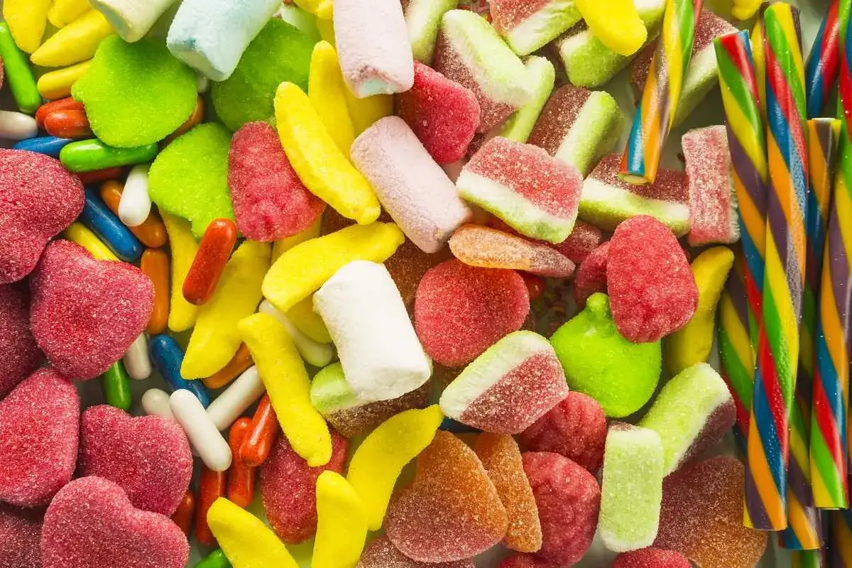 Un surtido vibrante de dulces celiacos: gomitas de frutas, malvaviscos y bastones de caramelo arco&iacute;ris.