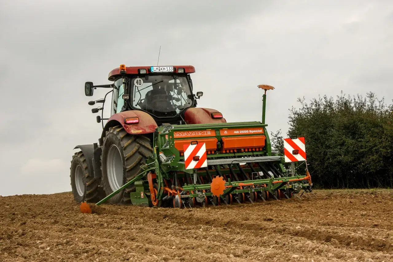 Traktor mit Amazone S&auml;maschine f&uuml;r die Roggen Aussaat auf einem Feld.