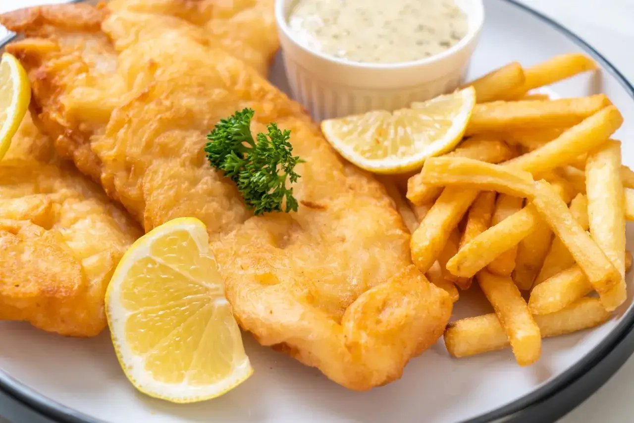 Chrupiące fish and chips z cytryną i sosem tatarskim. Idealny posiłek na szybki lunch.