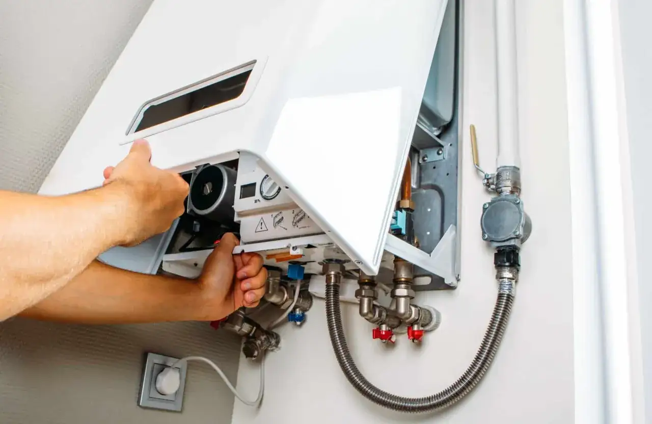 Tecnico che effettua la prima accensione caldaia, controllando i collegamenti idraulici e elettrici.