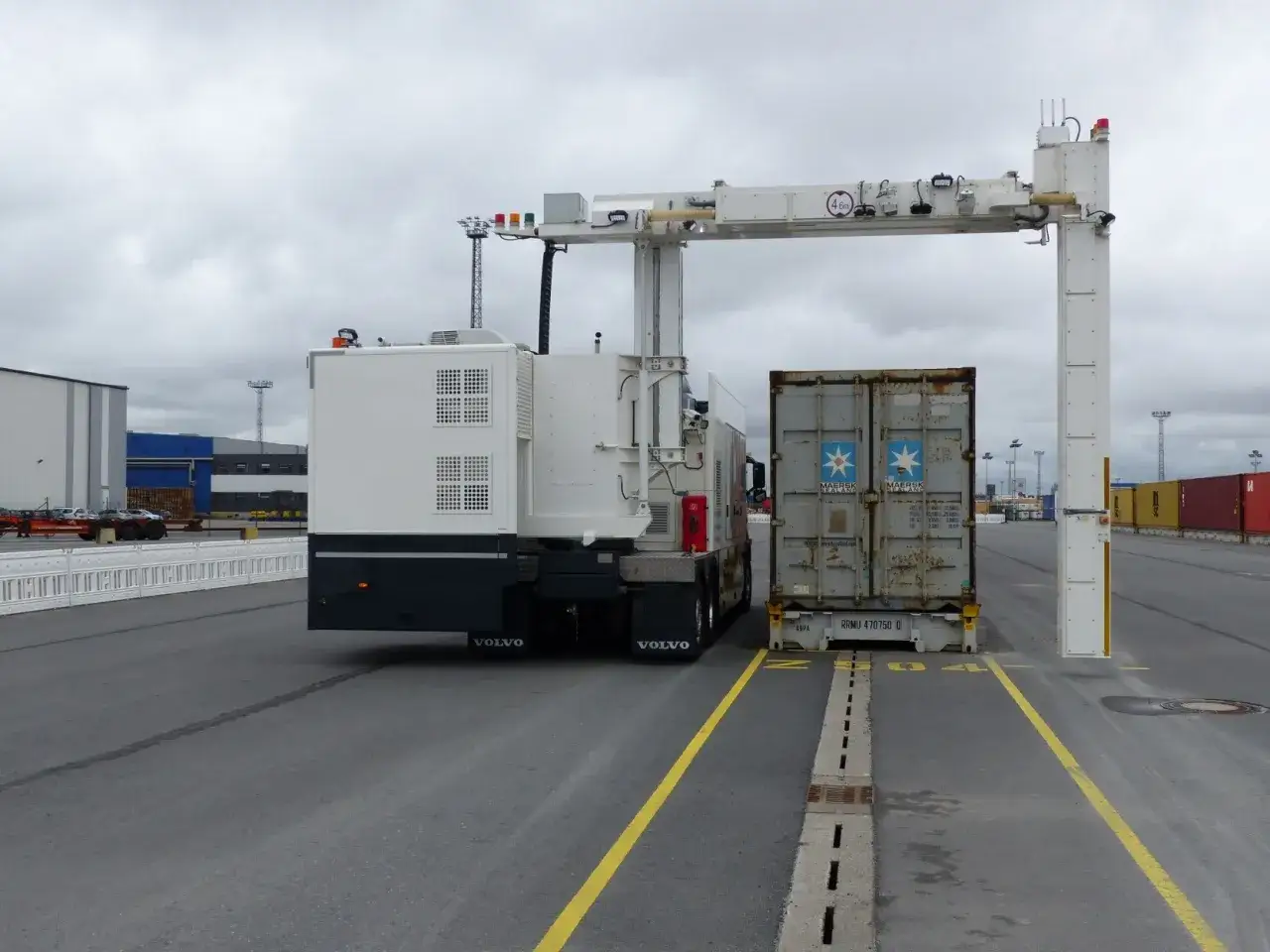 LKW mit Container unter einem R&ouml;ntgenscanner. Die Zollabfertigung ist im Gange.