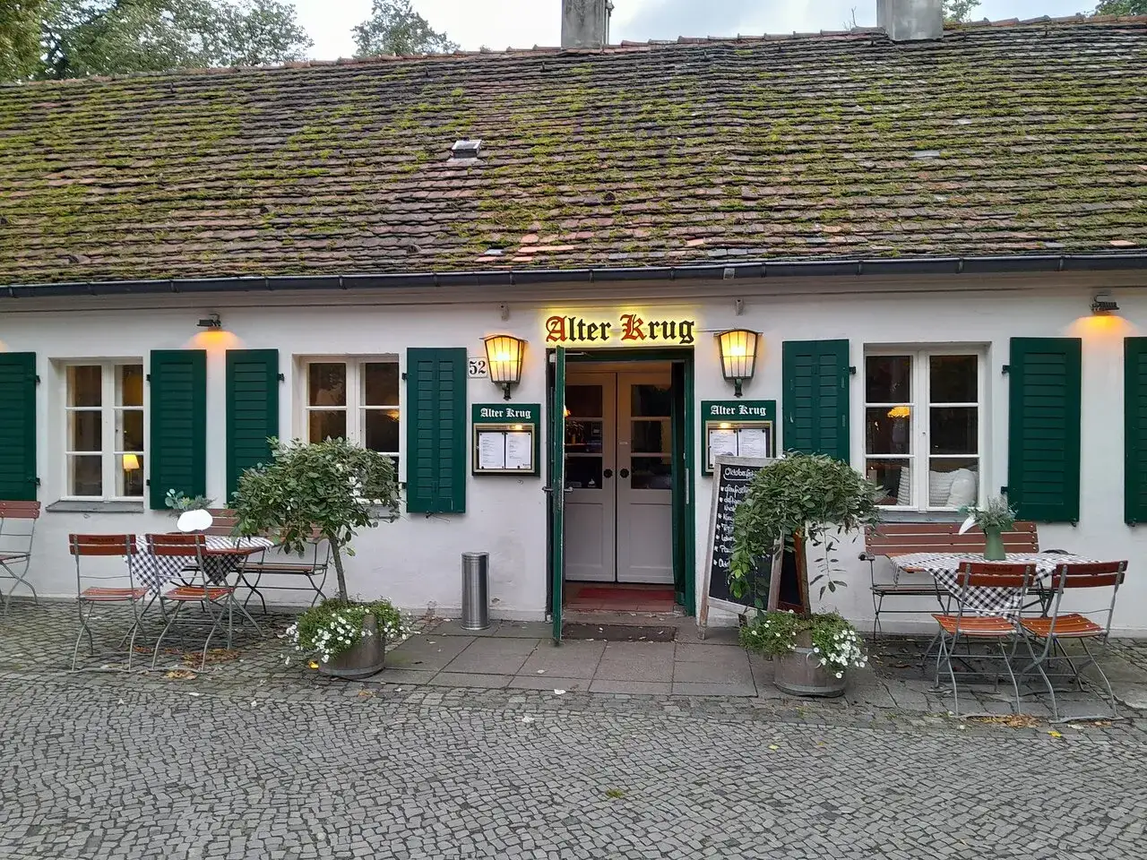 Der **Alte Krug Dahlem** l&auml;dt mit seinem charmanten Au&szlig;enbereich zum Verweilen ein. Gr&uuml;ne Fensterl&auml;den und ein moosbewachsener Dachziegel verleihen dem Geb&auml;ude Charakter.