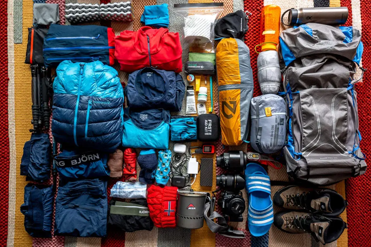 Pakowanie do Norwegii: ciepłe ubrania, śpiwór, plecak, buty trekkingowe, termos, apteczka i sprzęt fotograficzny.